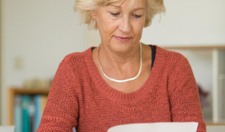 Vrouw leest uitnodigingsbrief bevolkingsonderzoek borstkanker