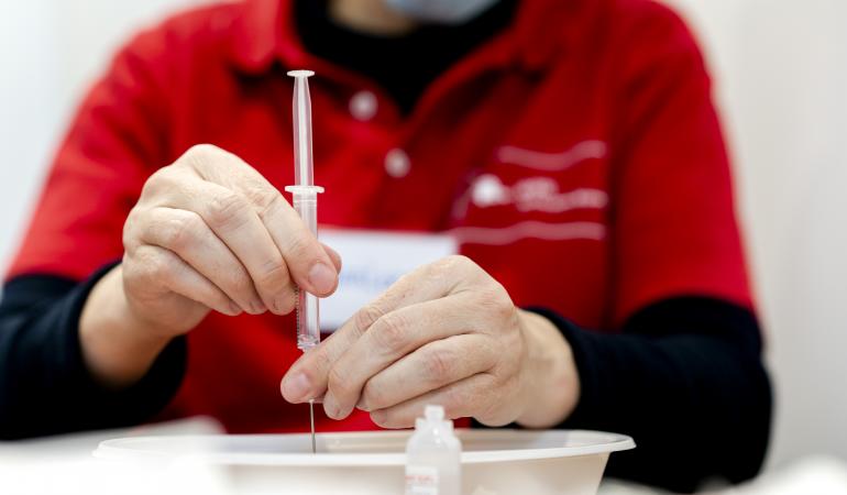 Vrouw maakt corona vaccin klaar bij GGD Rotterdam