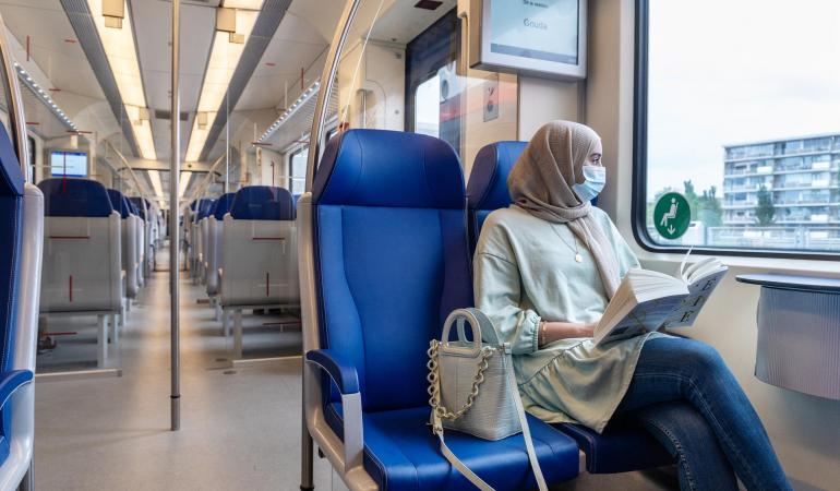 Vrouw met mondmasker in de trein