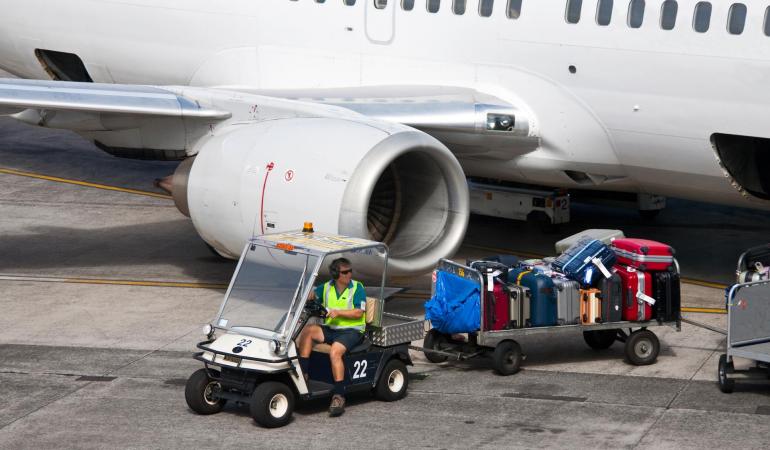 Het transport van koffers vanuit de laadruimte van een vliegtuig