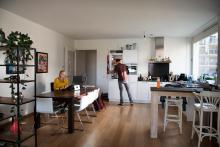 Vrouw aan het thuiswerken, man aan het koken