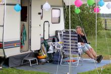 Man zit voor zijn caravan