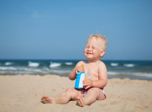 Baby met zonnebrand op het strand