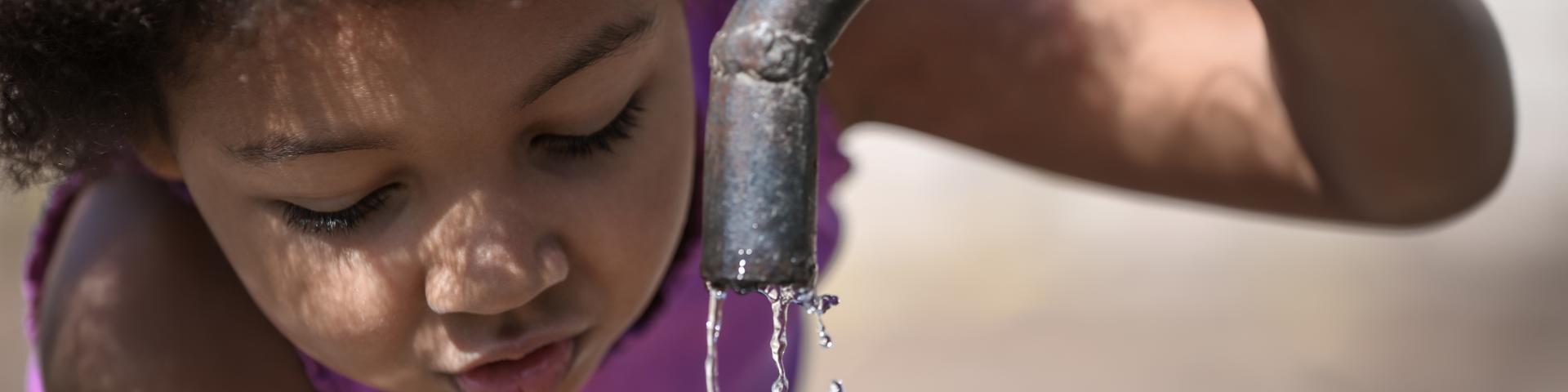 kind drinkt water aan kraan