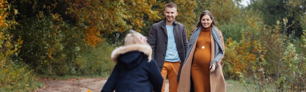 Zwangere vrouw met man en kind in het bos