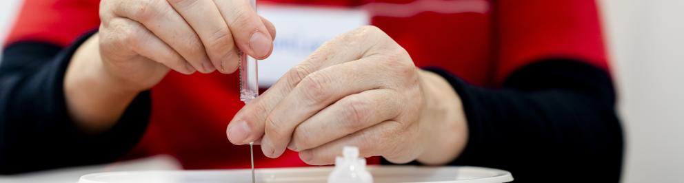 Vrouw maakt corona vaccin klaar bij GGD Rotterdam