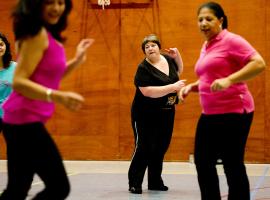 Vier dames met verschillend gewicht en postuur doen mee aan een sport- of dansles