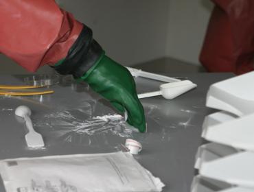 mans hand in safety clothing handling a powder letter