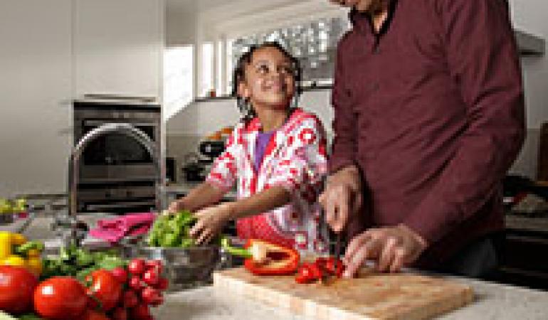 Man kookt met kind en maakt gebruik van gescheiden snijplanken. Een voor kip en een voor groenten.