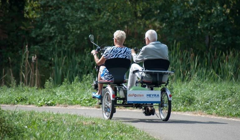 Twee ouderen op een duofiets