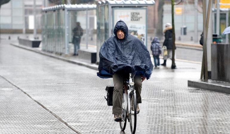 Man fietst door de regen