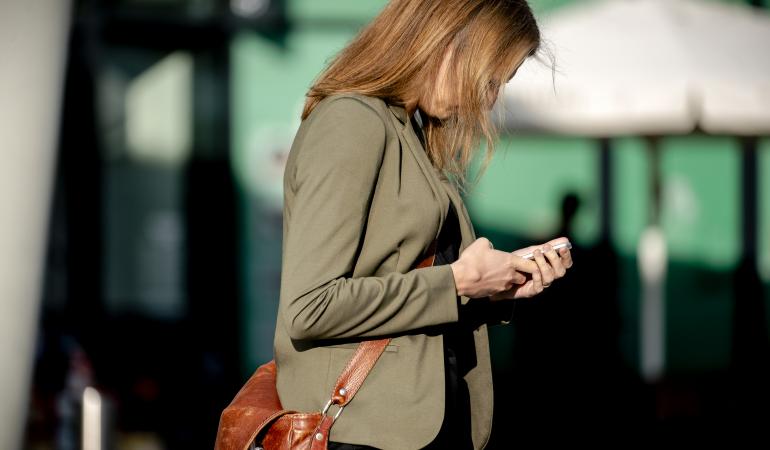 Vrouw kijkt op mobiele telefoon