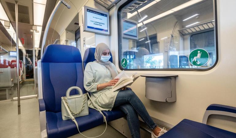 Vrouw met mondkapje in de trein
