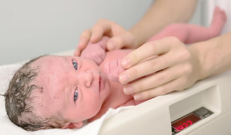Pasgeboren baby op de weegschaal