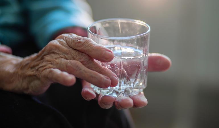 Oudere met glas water