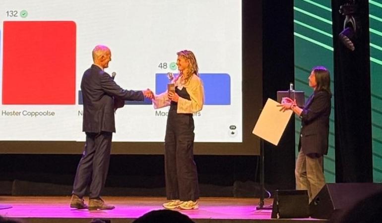Op de foto ontvangt Hester Coppoolse de prijs uit handen van Jim van Steenbergen. Rechts staat Monica Wong, voorzitter van de jury.