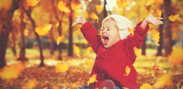 foto van blij kind in de herfstbladeren