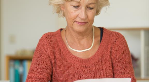 Vrouw leest uitnodigingsbrief bevolkingsonderzoek borstkanker