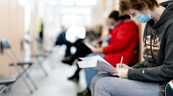 mensen wachten op vaccin