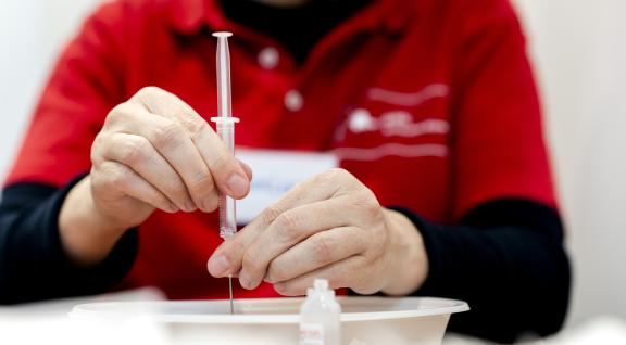 Vrouw maakt corona vaccin klaar bij GGD Rotterdam