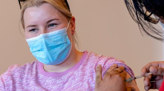 Jonge vrouw krijgt COVID-vaccinatie bij GGD
