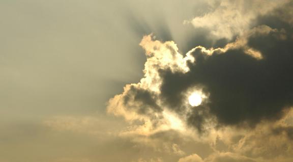 De zon door wolken versluierd
