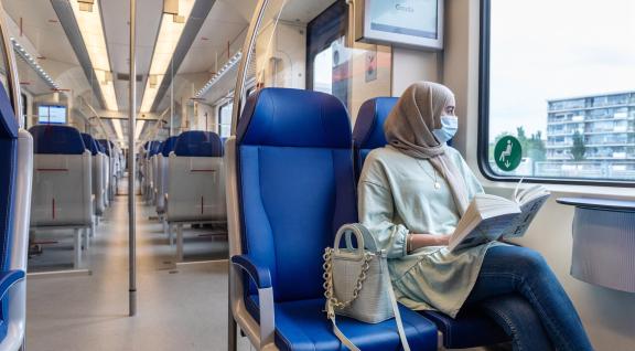 Vrouw met mondmasker in de trein