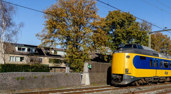 Trein rijdt langs huizen