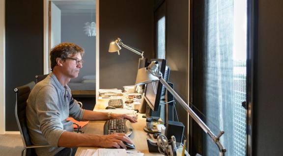 Man werkt thuis aan bureau