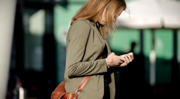 Vrouw kijkt op mobiele telefoon