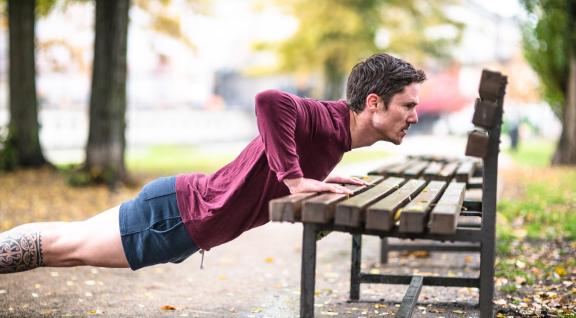 Hardlopen aan het rekken op een bank in het park