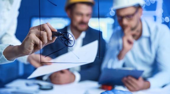 Twee werkmannen met helm in overleg