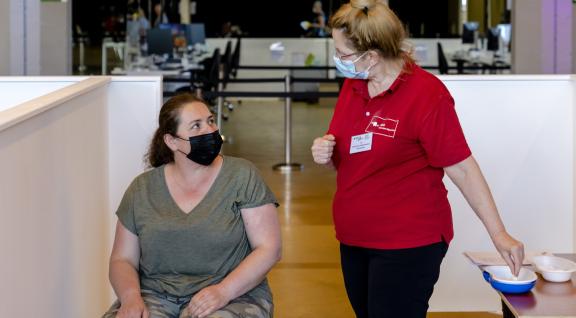 Vrouw krijgt uitleg over COVID-19 vaccinatie
