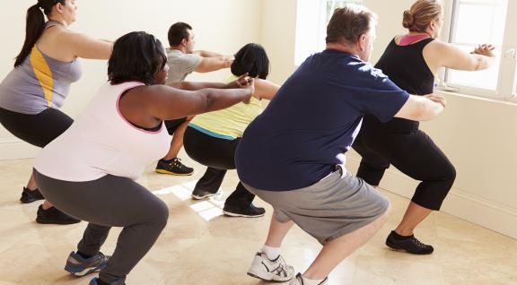 Groep mensen aan het sporten in een sportschool