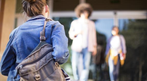 Jongeren lopen een gebouw in en uit