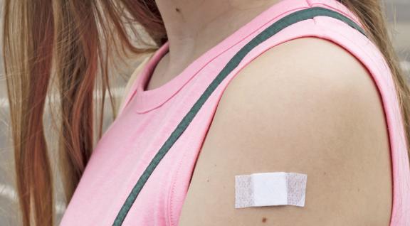 Vrouw met pleister op arm na vaccinatie