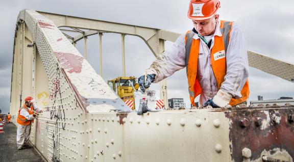 Wegwerkers schilderen een brug