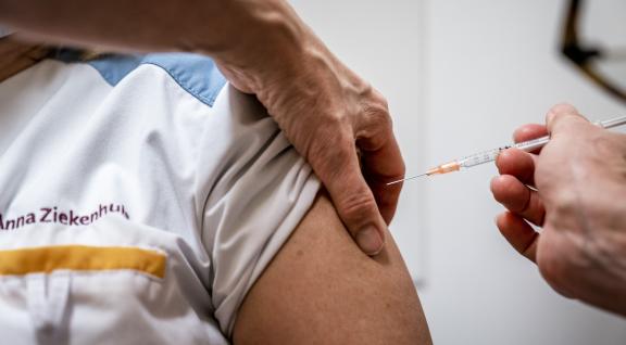 Zorgmedewerker ontvangt de booster vaccinatie (Covid-19)