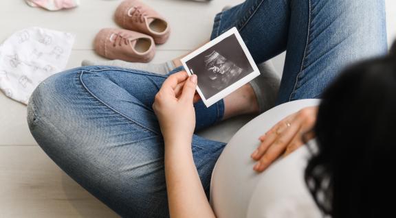 Vrouw bekijkt echo foto van baby