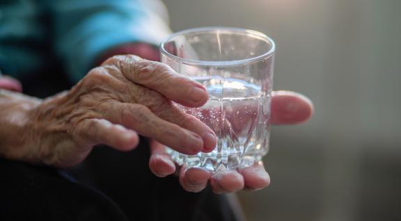 Oudere met glas water