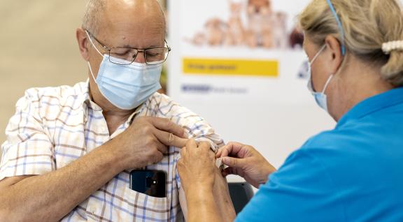 Oudere man krijgt vaccinatieprik
