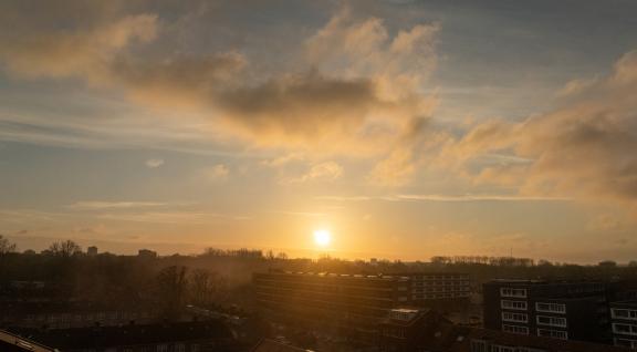 Mist boven een wijk met zonopkomst