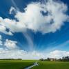 Typische Hollandse wolkenlucht met op de horizon een boerderij