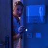 Verpleegster schijnt met nachtlampje in ziekenhuiskamer